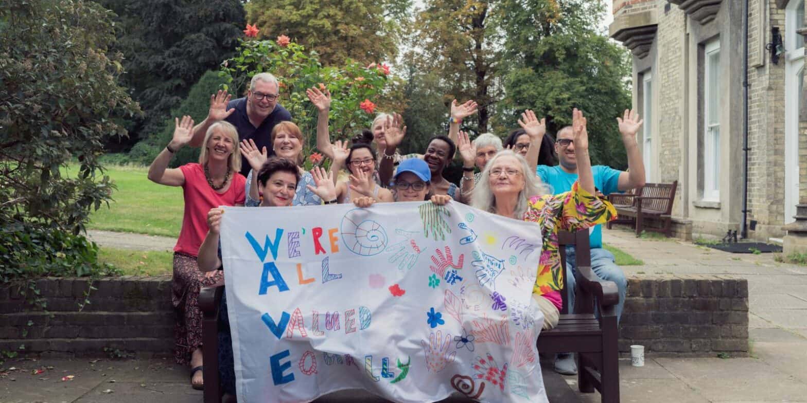 A group of diverse people holding a banner