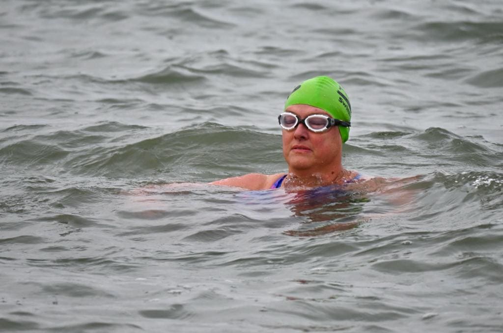 Close up of Jo Lorimer treading water in the sea wearing cap and goggles.