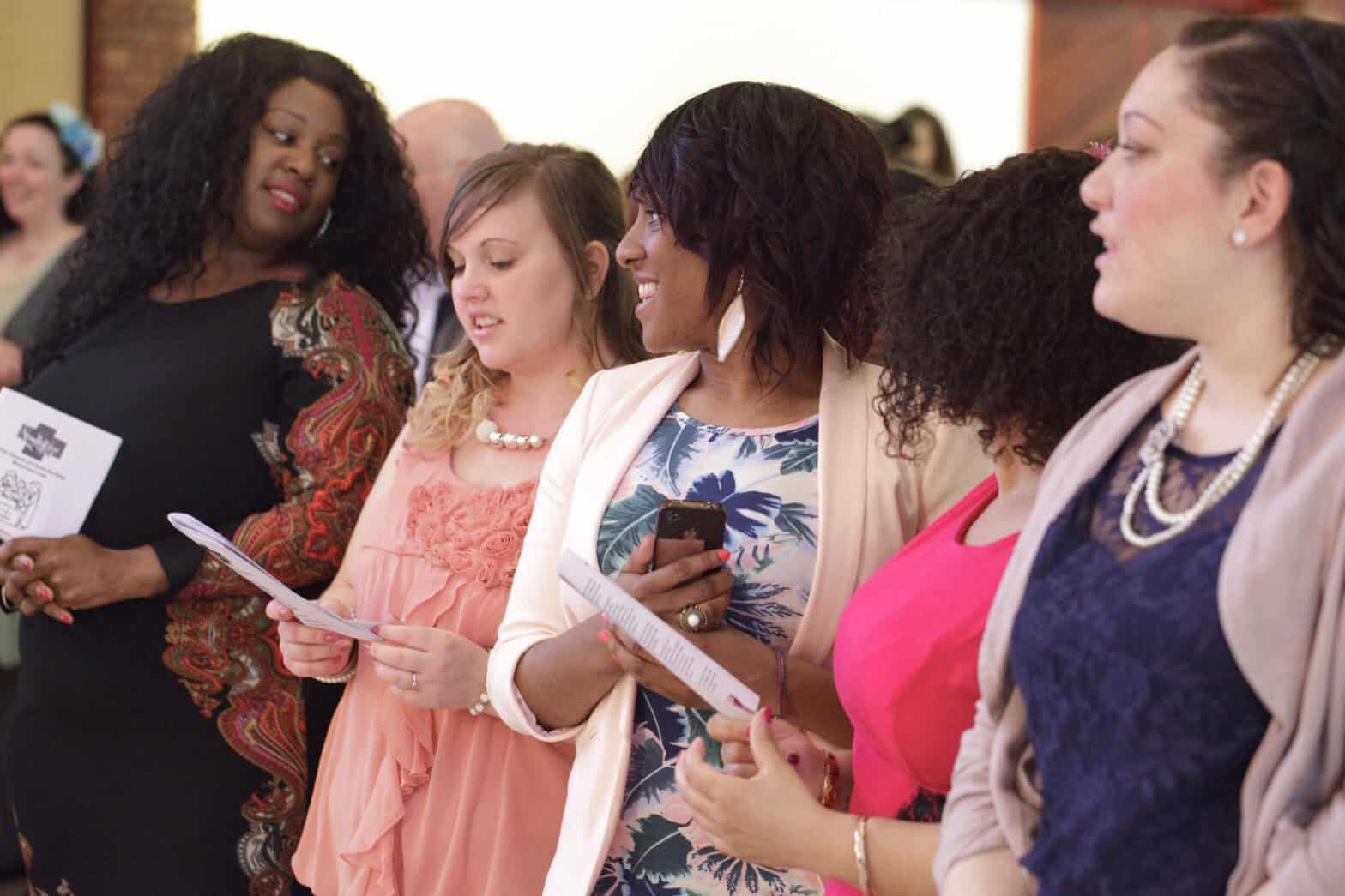 Group of five young women singing a hymn in a church