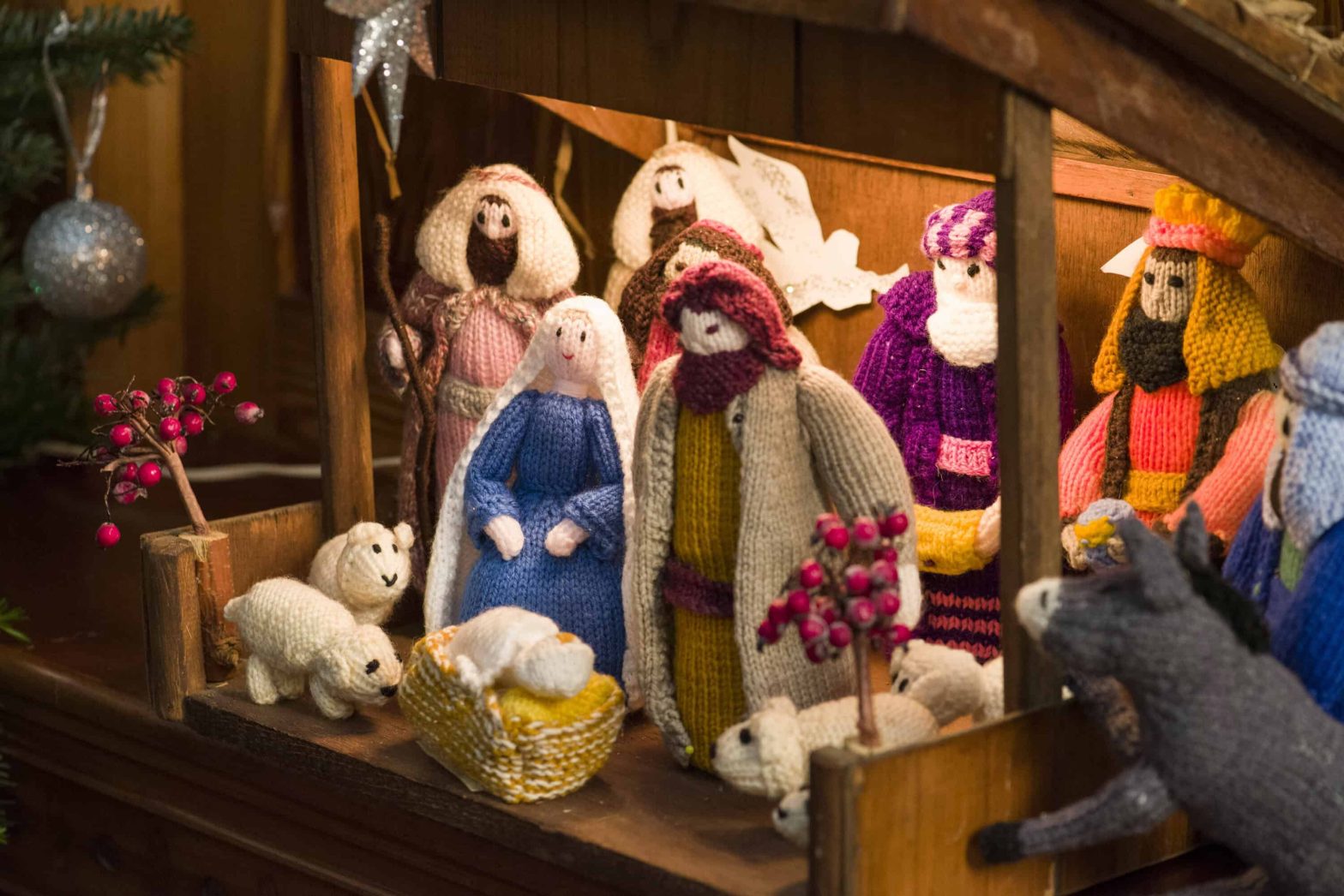 Knitted nativity characters in a small wooden stable.