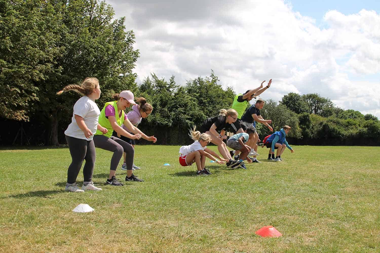 Line of children on a field jumping.