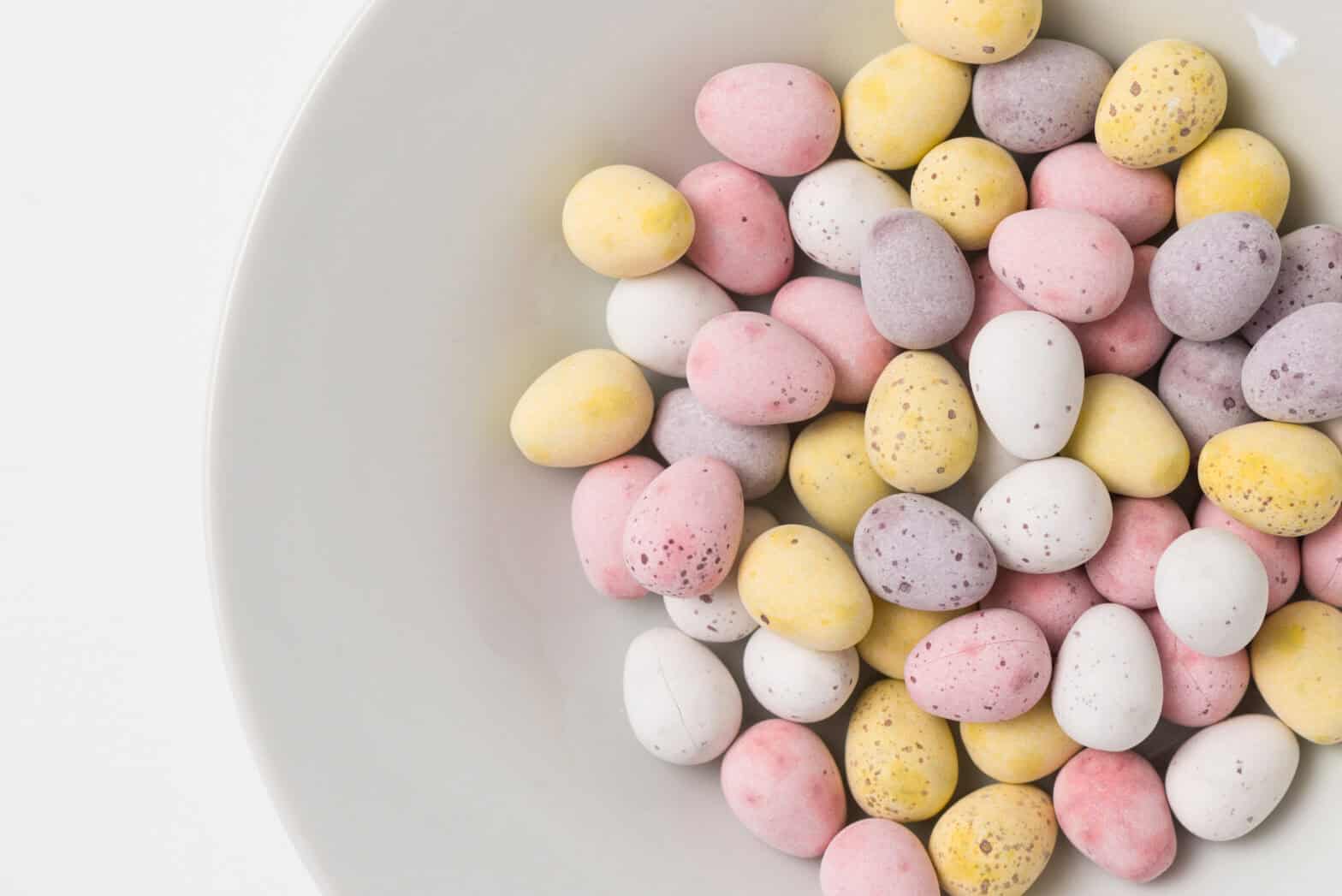 Lots of colourful chocolate mini eggs in a bowl.