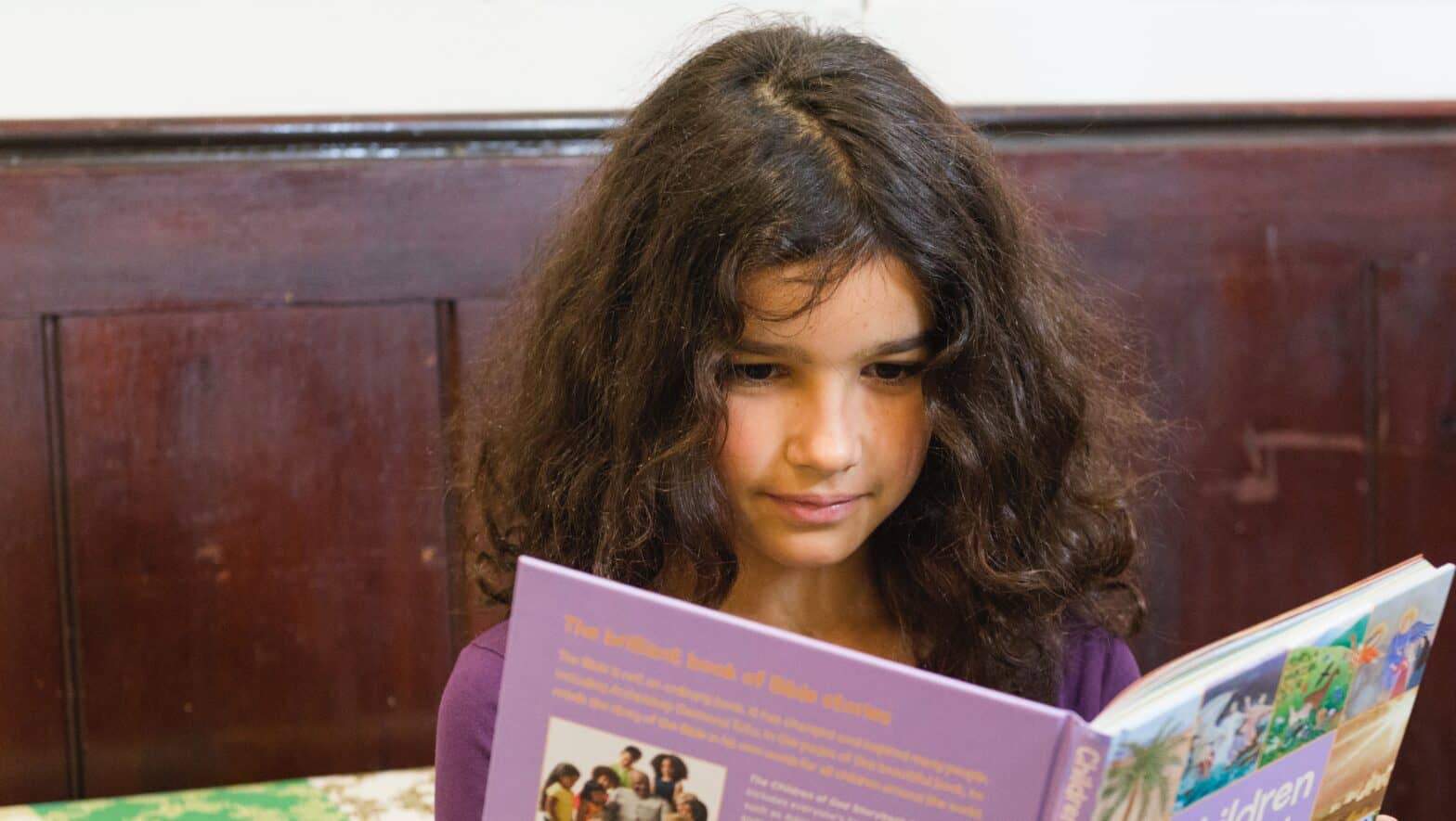 Older girl reading a book in church