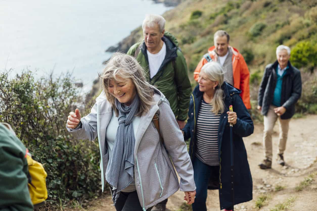 Small group of older people on a coastal walk.