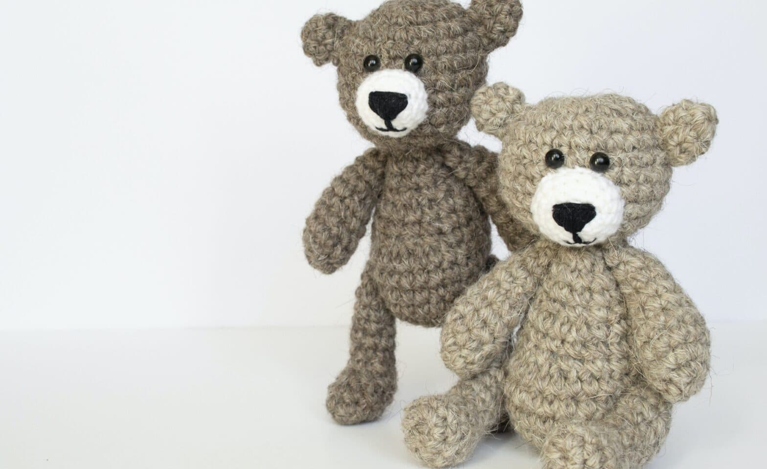 Crocheted gray and brown bears on a white background.