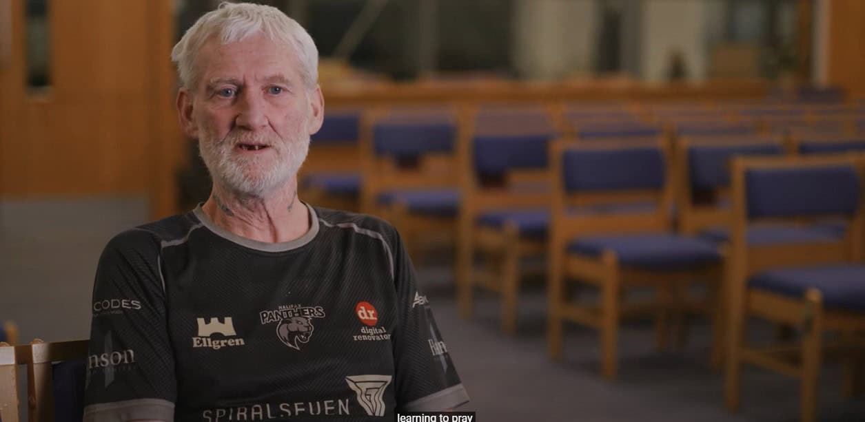 Man sitting in chair at a church being interviewed