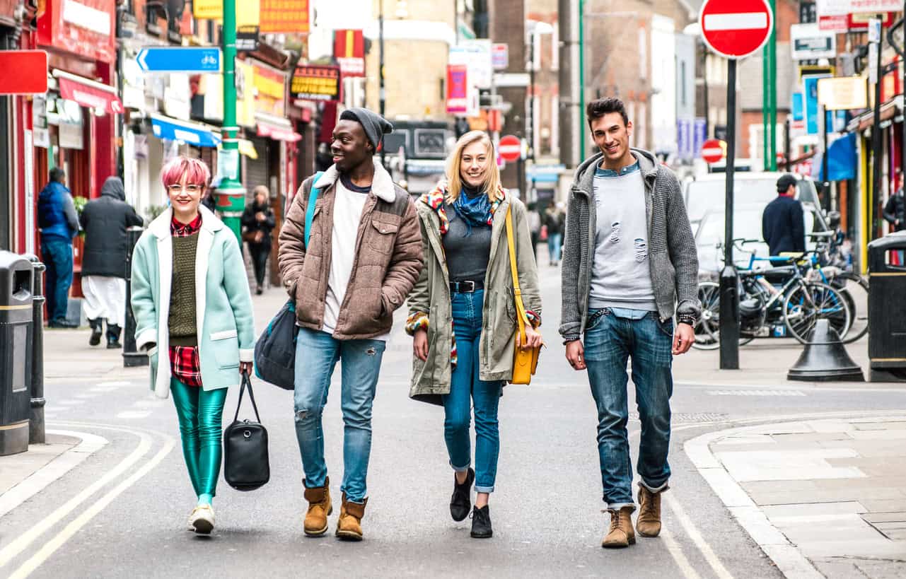 Group of stylish teenagers walking across a road together