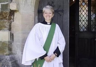Vicar standing in front of church door and smiling