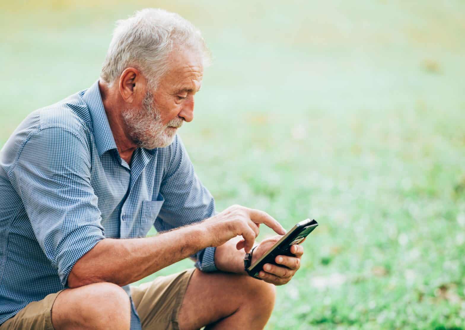 Older gentleman looking at a Smartphone