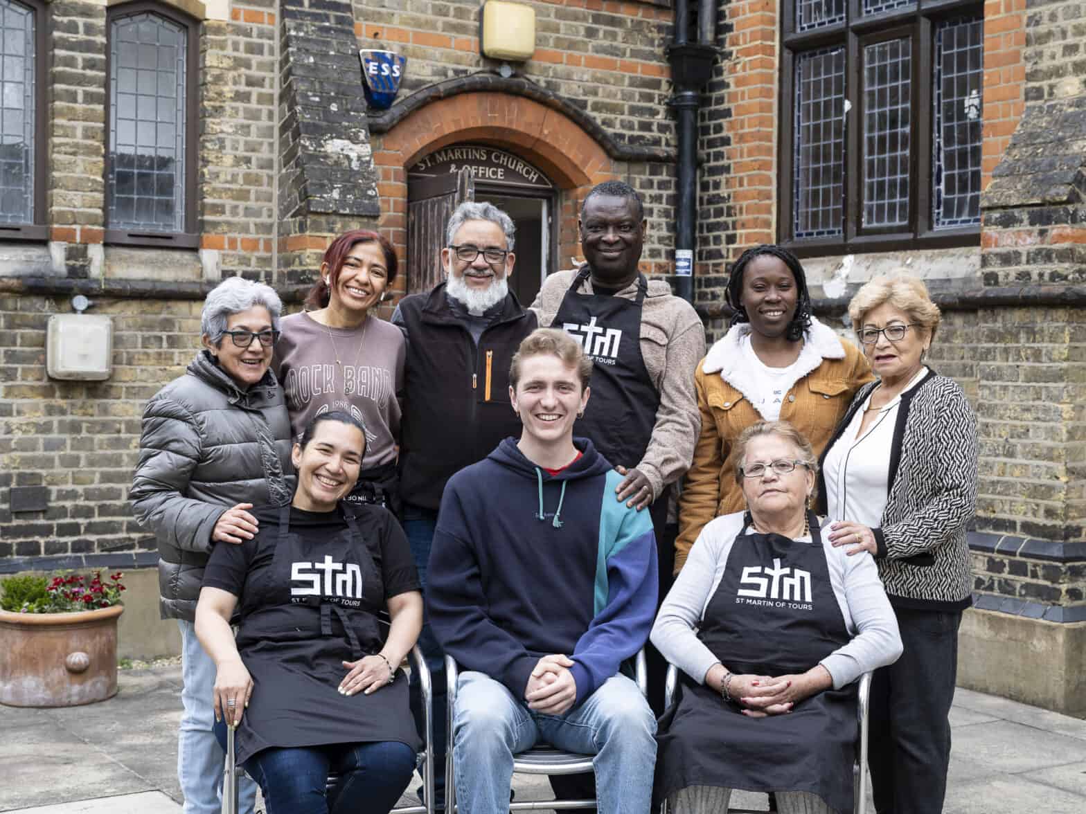 Group of nine people who look like friends standing together outside a church