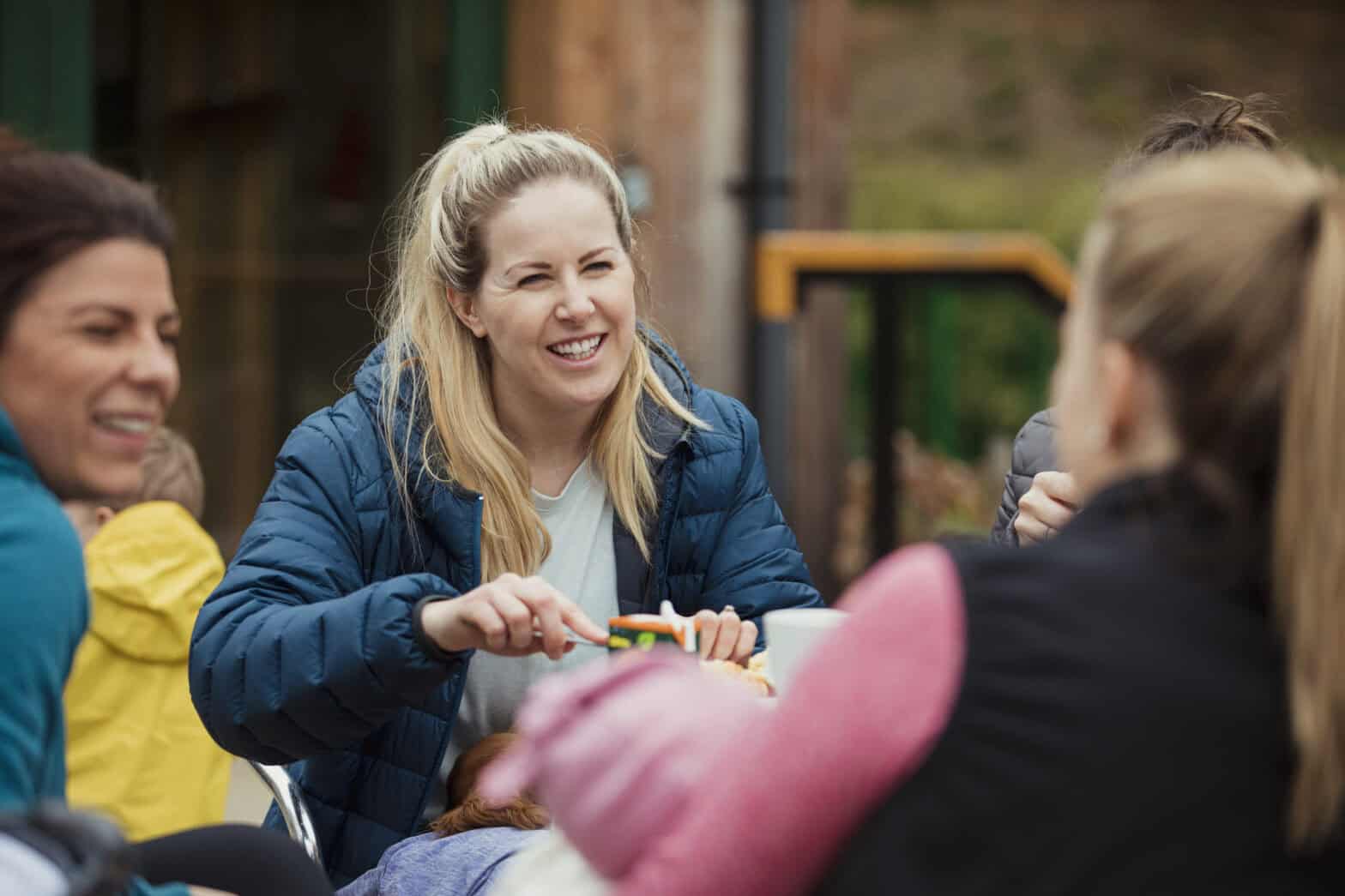A group of women outside at a park sitting down in coversation