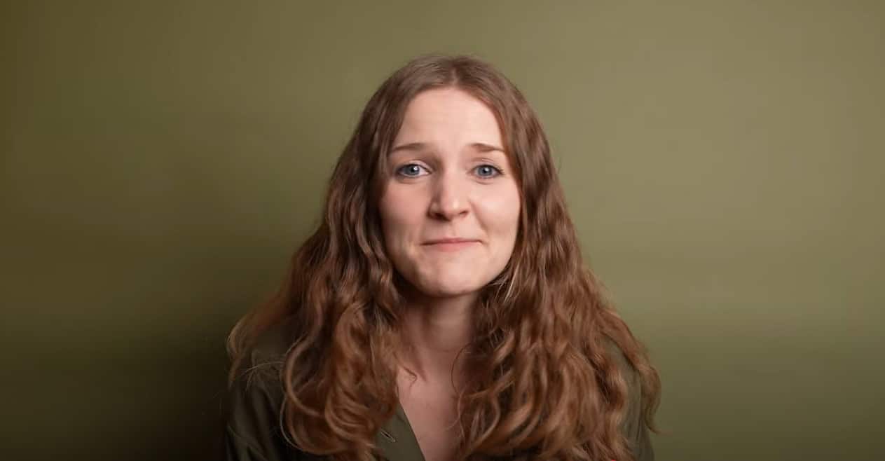 Woman against olive background speaking