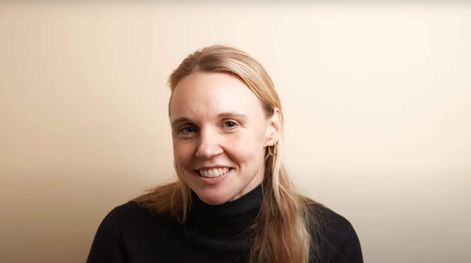 Woman wearing black turtleneck and smiling