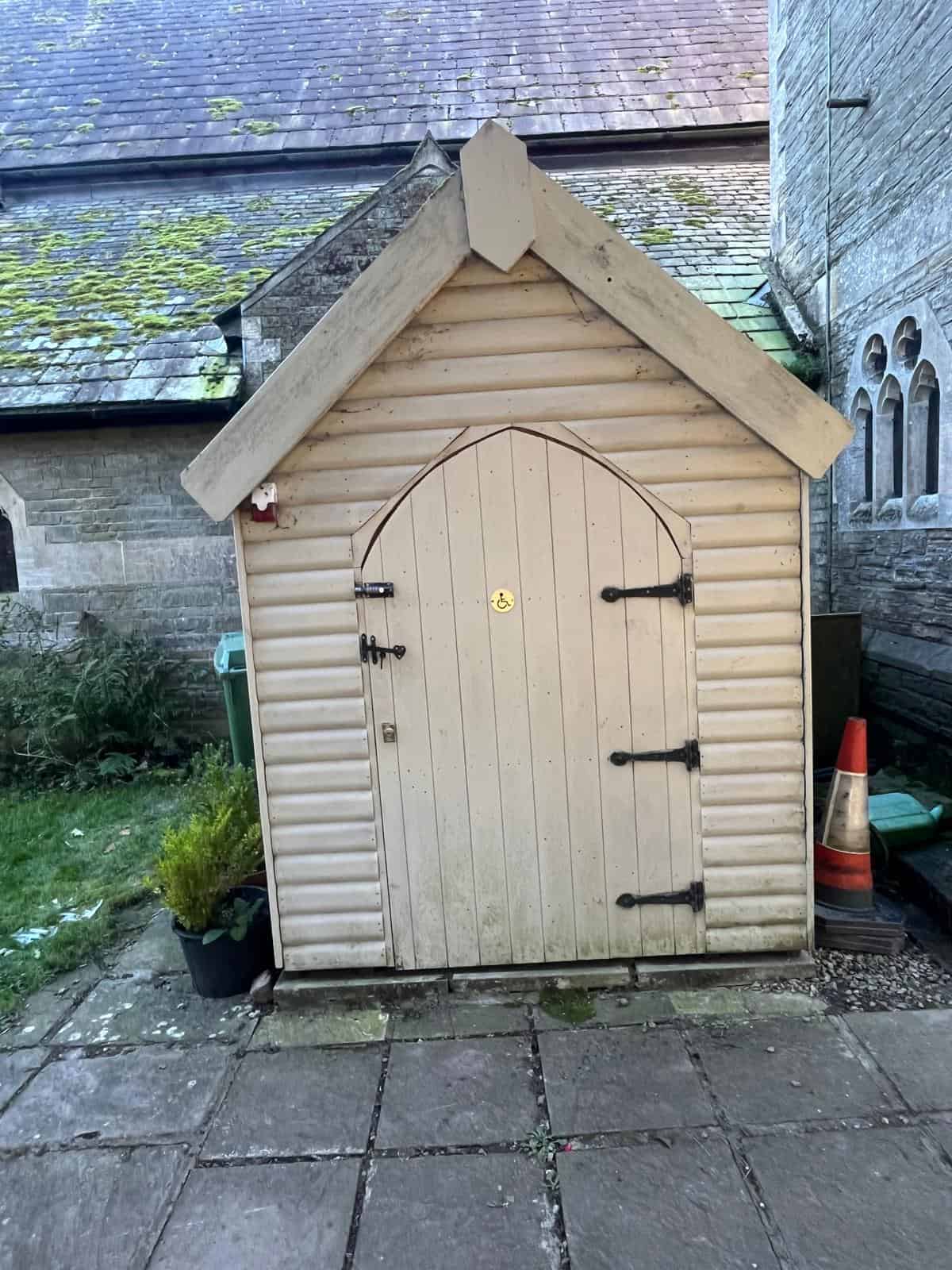 Small beach-hut style compostable restroom made from wood and looking like a small gardening shed