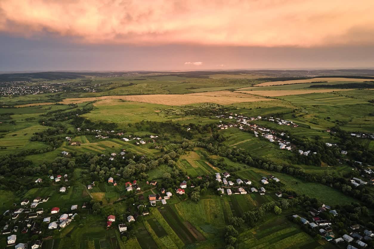View of houses from the air, surrounded by green fields