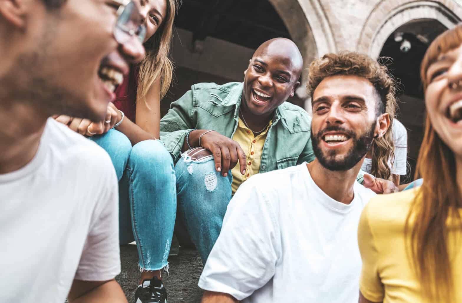 Young people sitting outside a church and sharing a joke