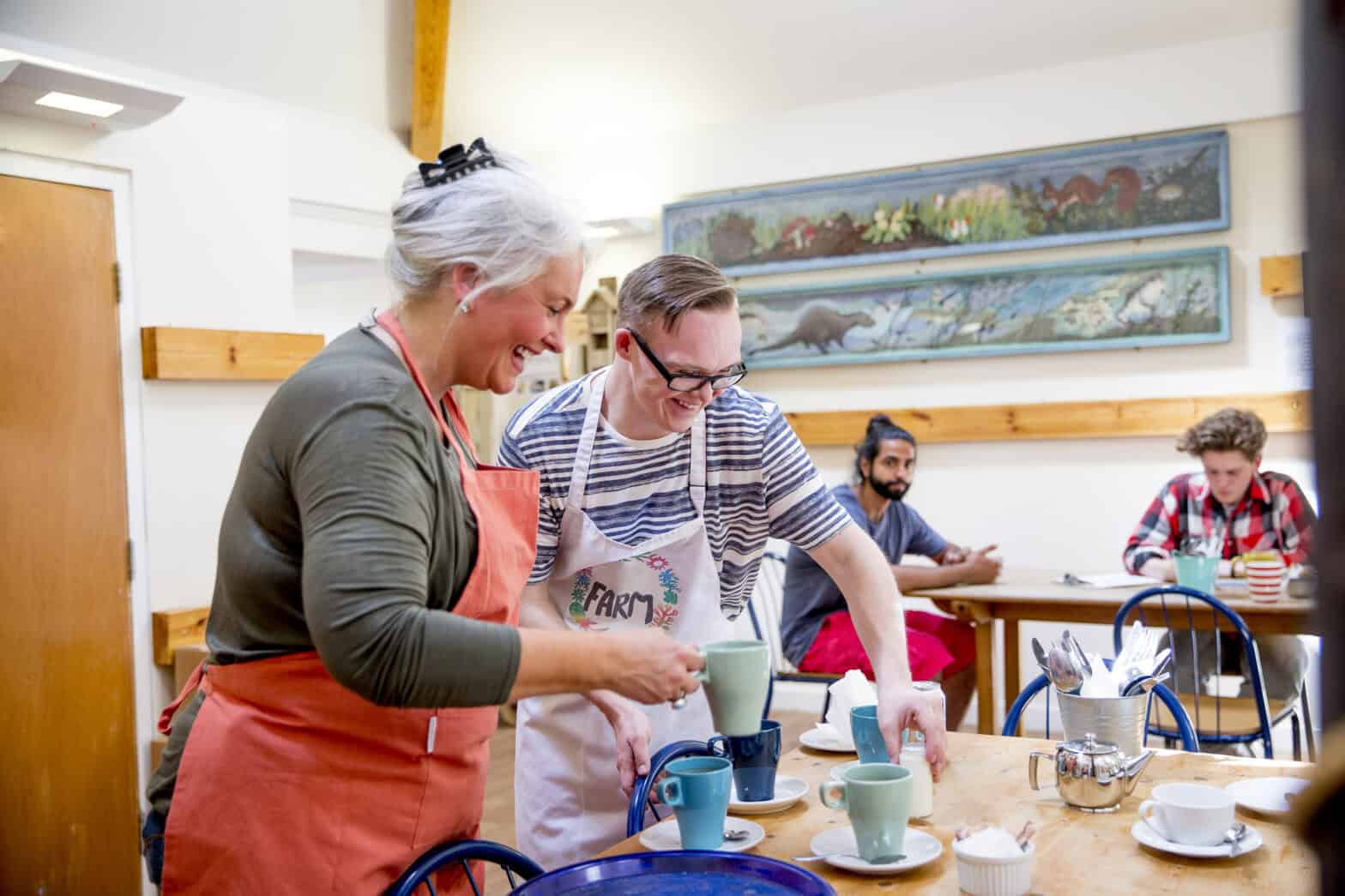 Two people clearing a table in a cafe
