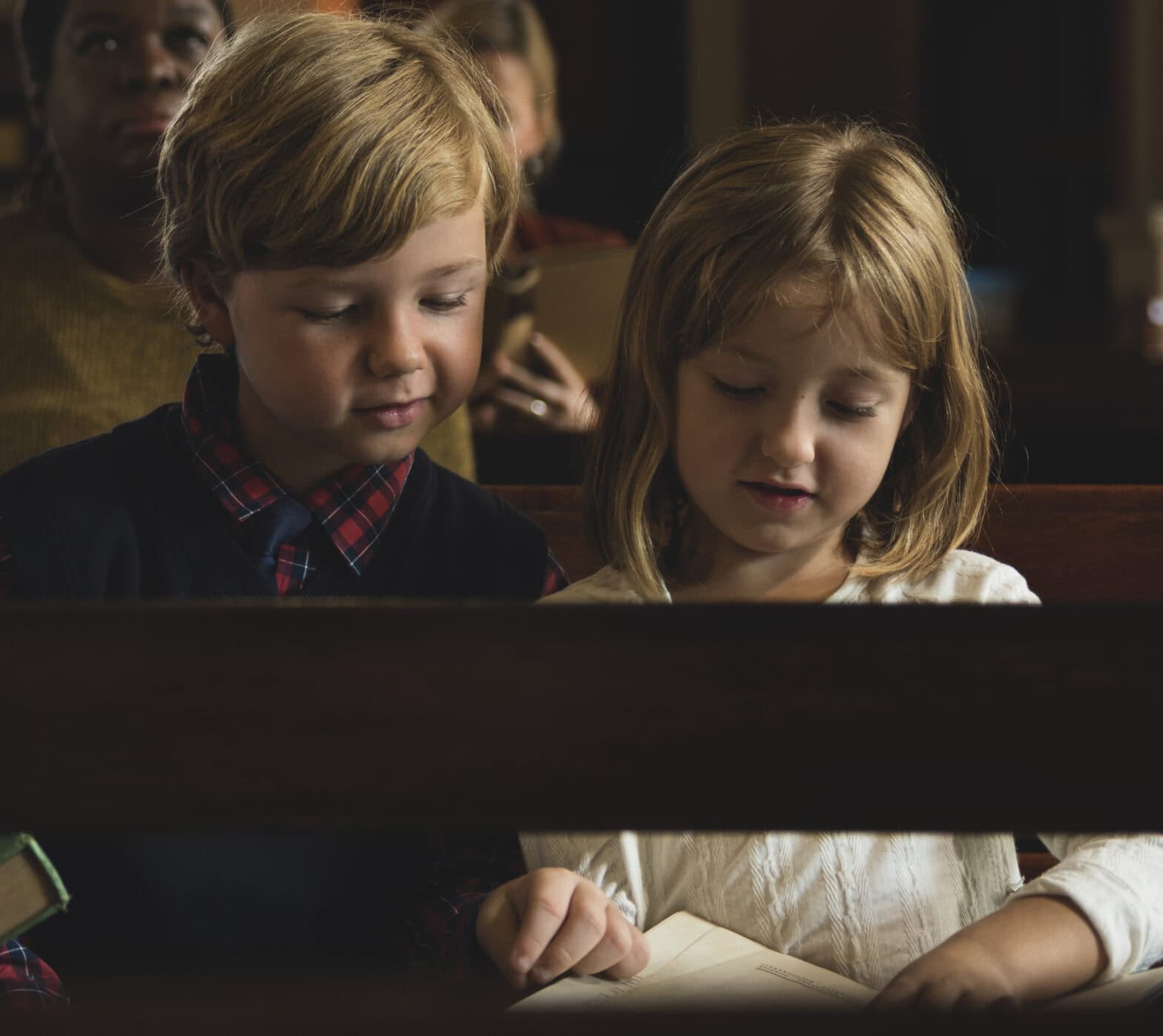 A young girl and a young boy participating in a church service