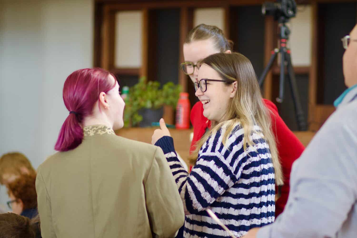 Three young people are having a friendly conversation at church.