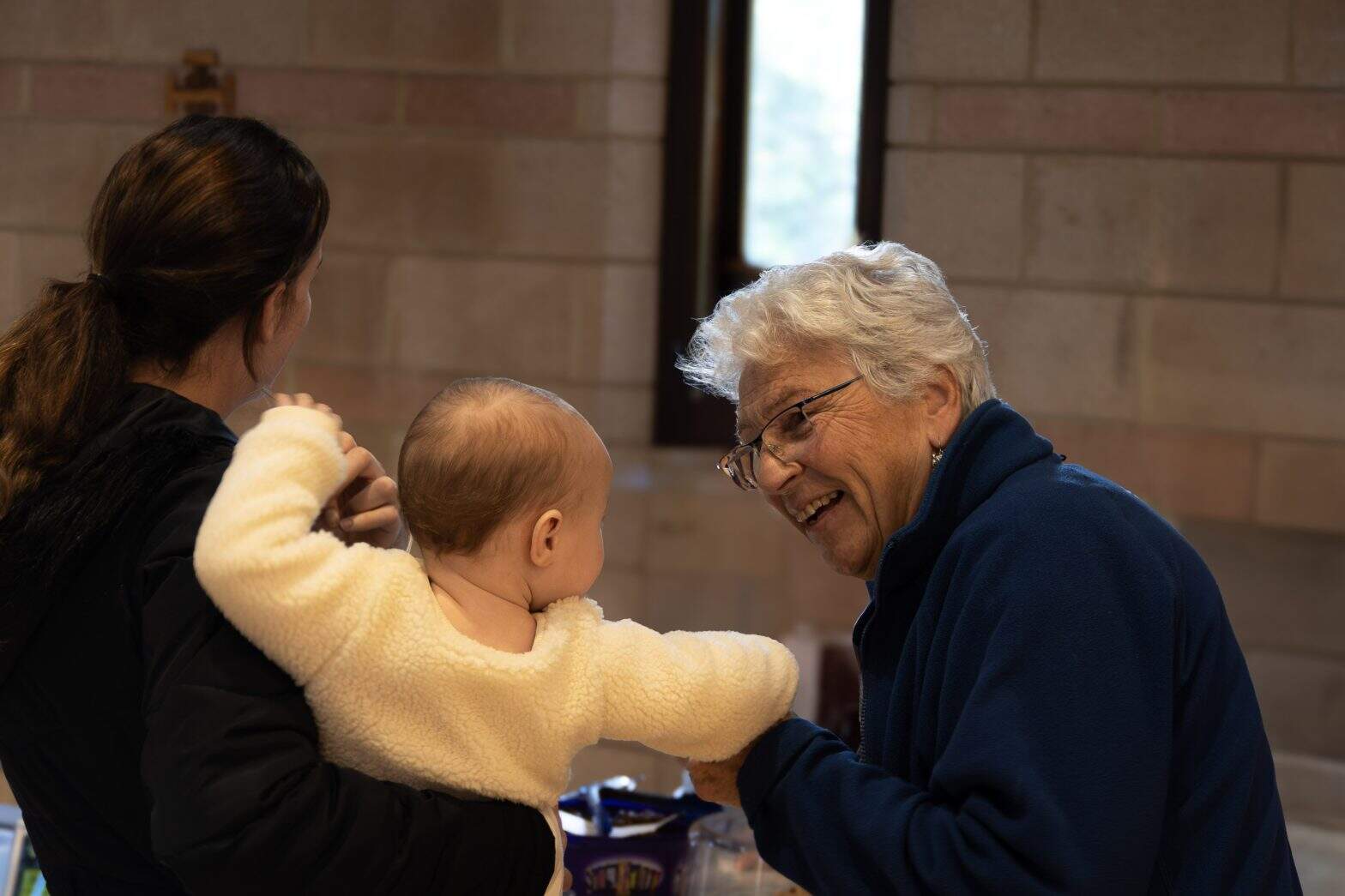 Mother holding a baby and talking to another woman in a church