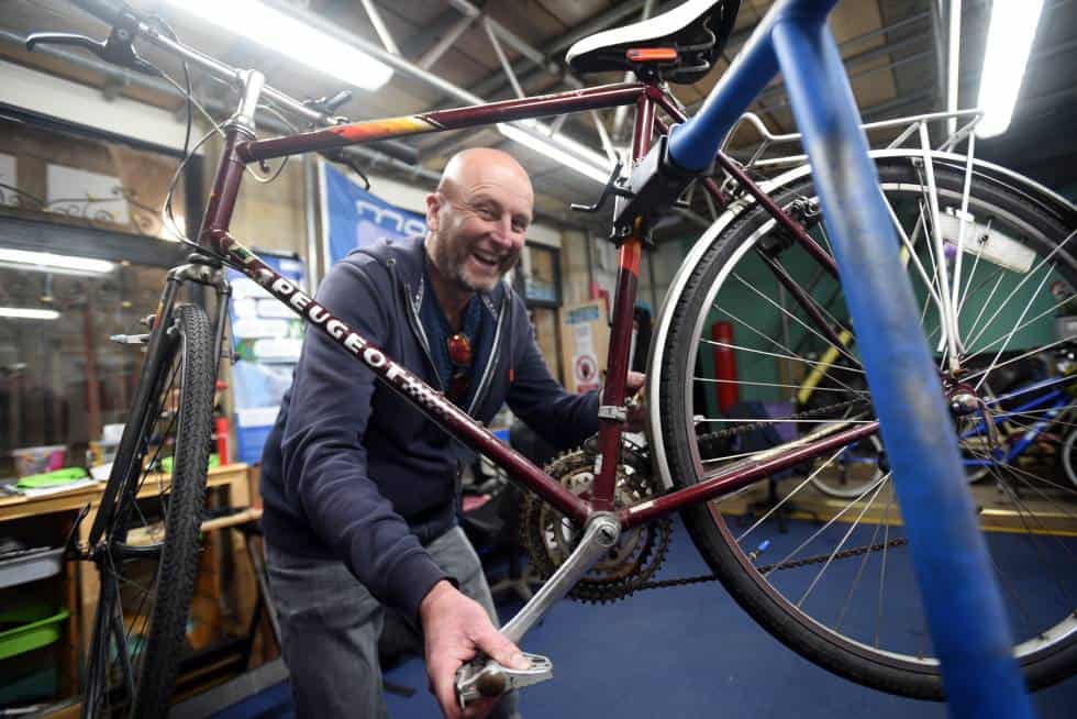 Man next to a bike as a part of the bike cafe
