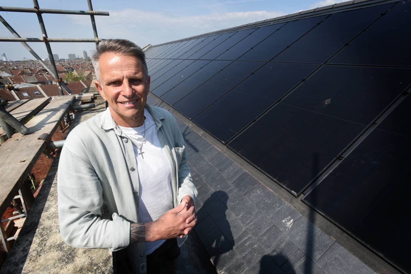 Man standing next to solar panels on the roof of a church