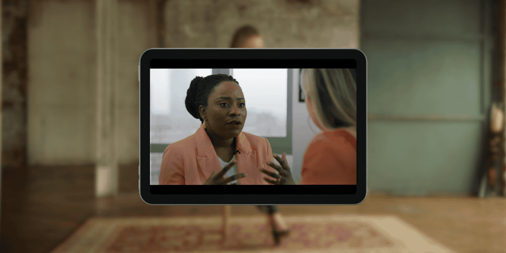 A woman being interviewed by another woman with animated hands.