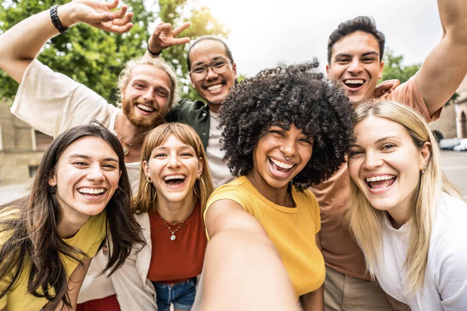 A group of young adults smiling to the camera representing happiness and confidence