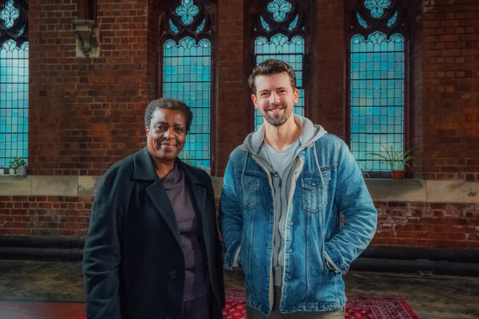 A woman and man looking to camera in a church in Birmingham