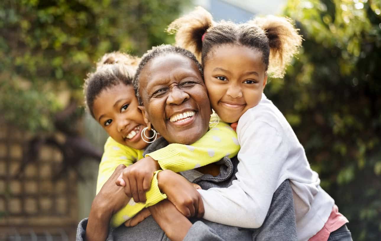 Happy family hugging outdoors, promoting faith and community support.